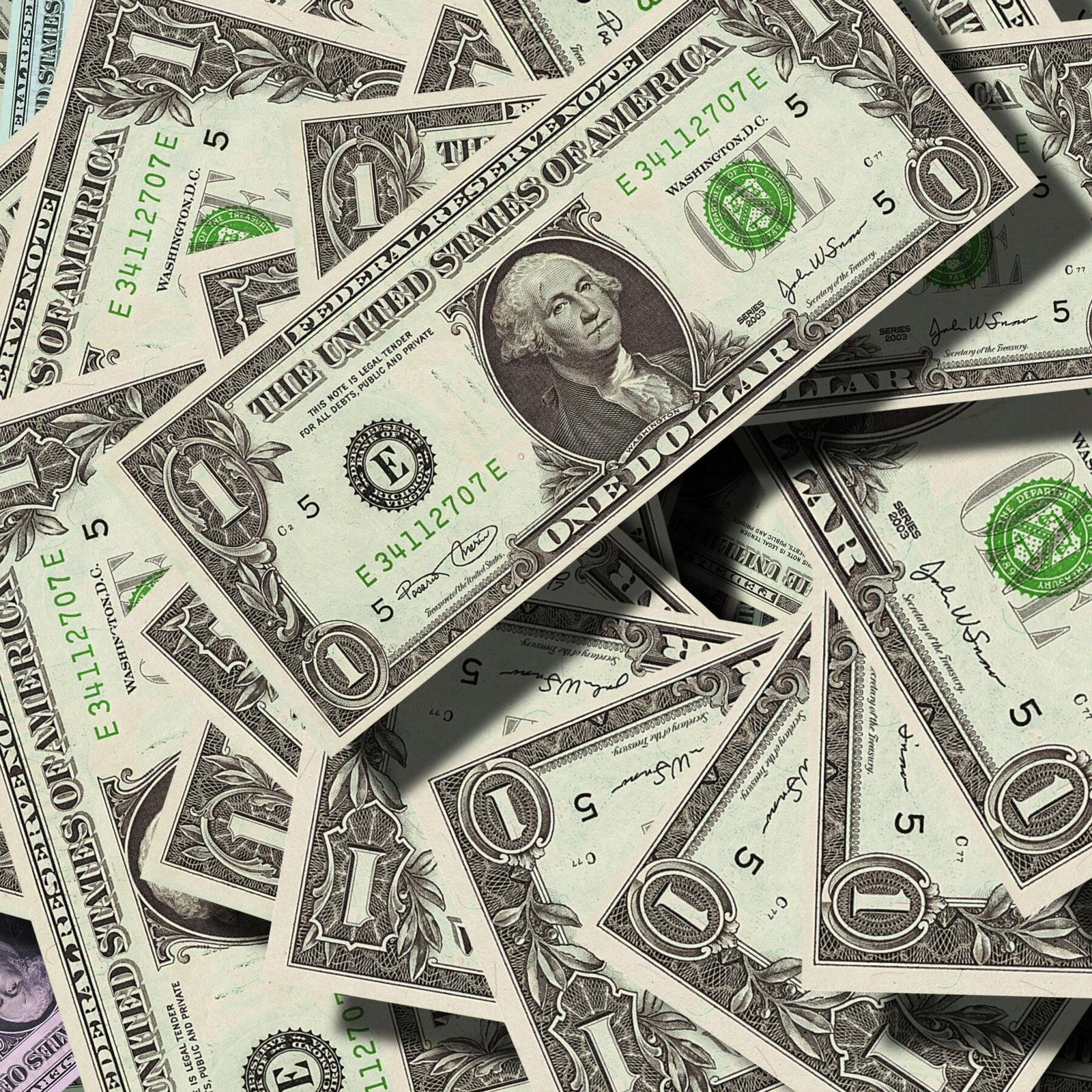 Close-up of scattered US dollar bills symbolizing finance and wealth.